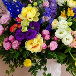Bright bouquet in a vase with delphinium and peonies