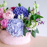 Rose-lilac composition in a wicker box