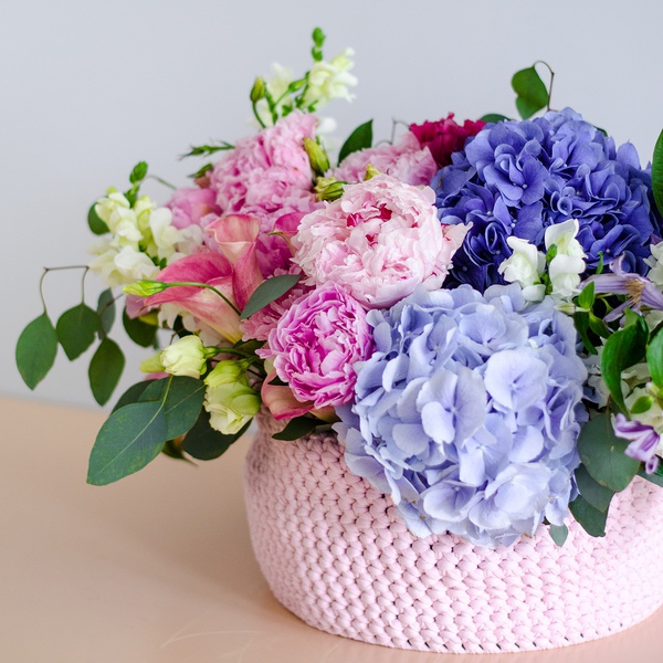 Rose-lilac composition in a wicker box