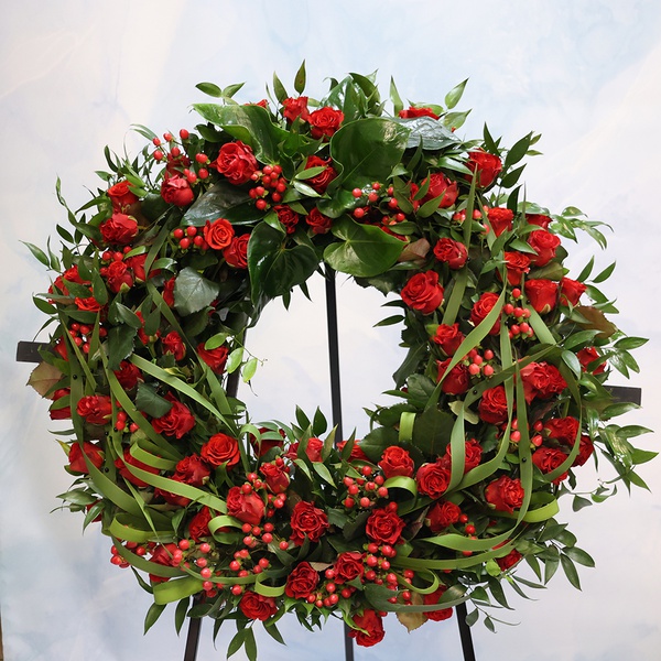 Mourning wreath in red tones with rose and hypericum