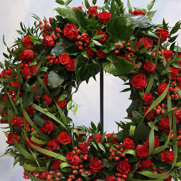 Mourning wreath in red tones with rose and hypericum