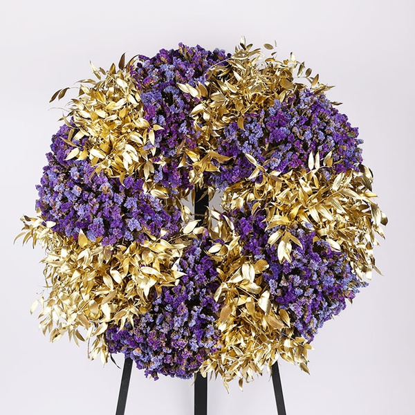 Funeral wreath made of statice and gold ruscus