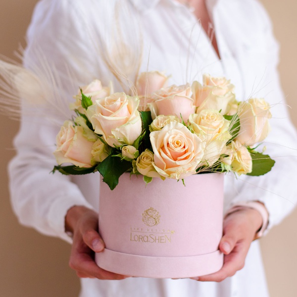 Composition in a box with roses and feathers
