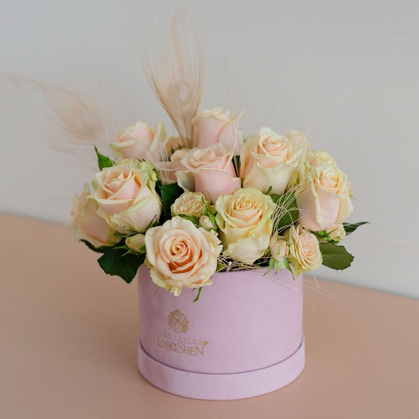 Composition in a box with roses and feathers