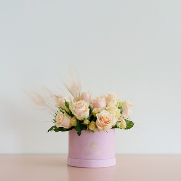 Composition in a box with roses and feathers