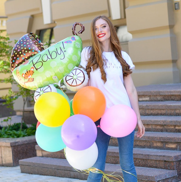 An armful of "Welcome baby" balloons