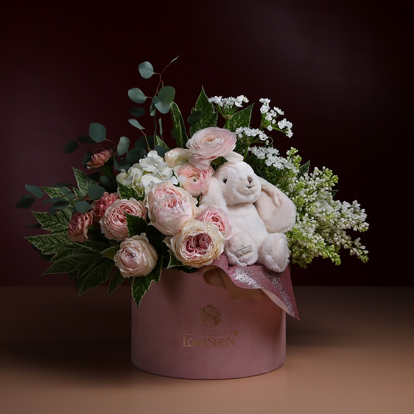 Flowers in a box with a soft toy bunny