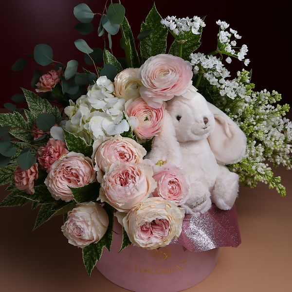 Flowers in a box with a soft toy bunny