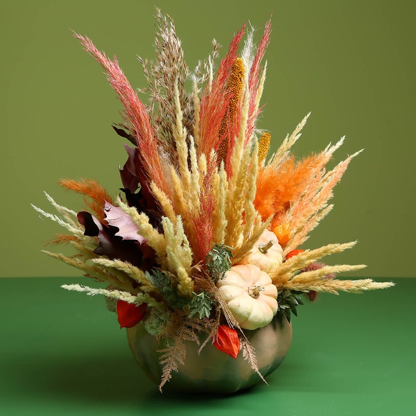 Flower in pumpkin with dried flowers