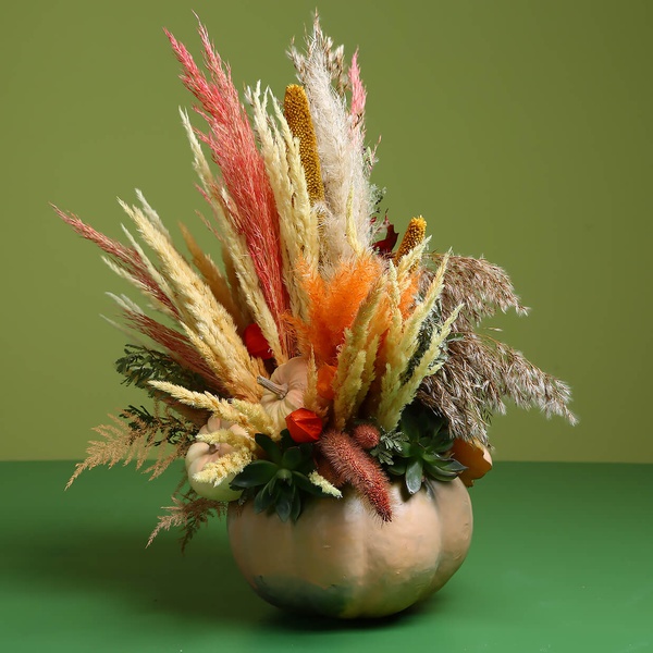 Flower in pumpkin with dried flowers