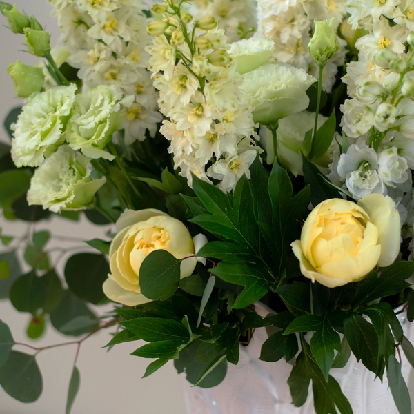 Bouquet with yellow peonies and delphinium in a vase