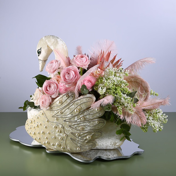 Floral composition in a Swan with pink ranunculus
