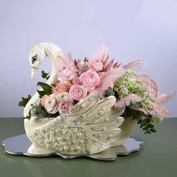 Floral composition in a Swan with pink ranunculus