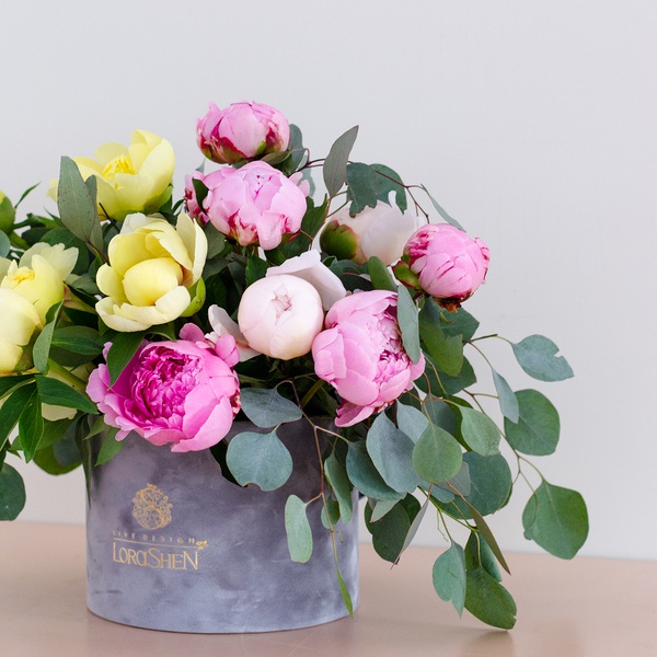 Yellow and pink peonies in a box