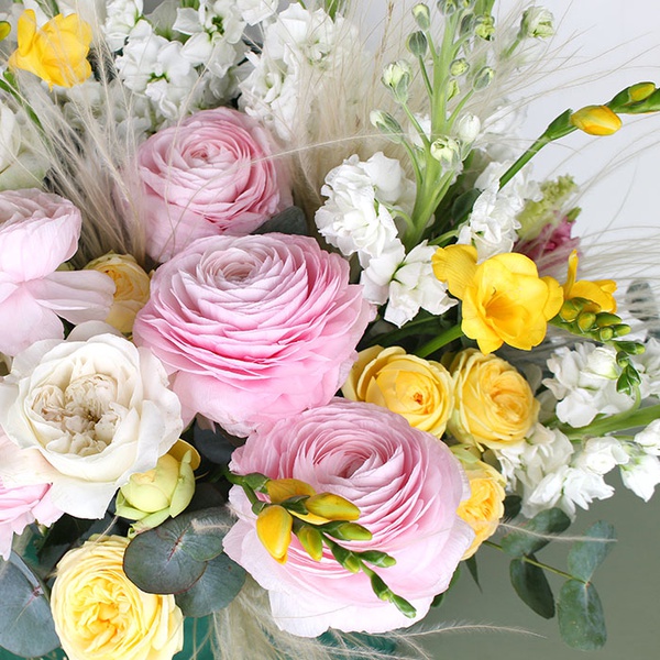 Composition with delicate ranunculus and sunny freesia