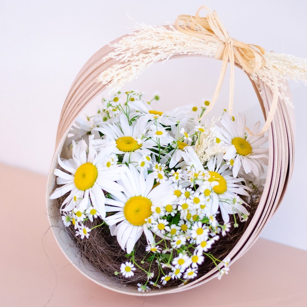 Floral composition of daisies in a basket