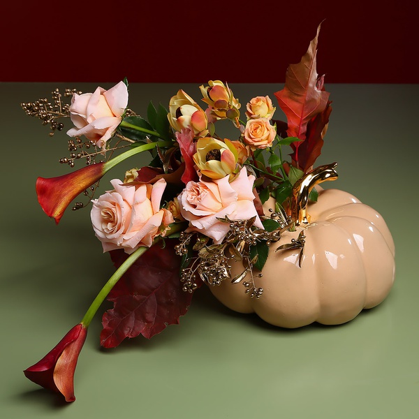Autumn composition in a pumpkin vase